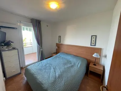 a bedroom with a blue bed and a window at Appartement T3 les pieds dans l'eau in Moriani Plage