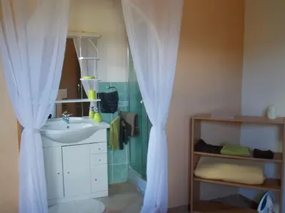 a bathroom with a sink and a shower curtain at Mini villa de charme. in Zonza