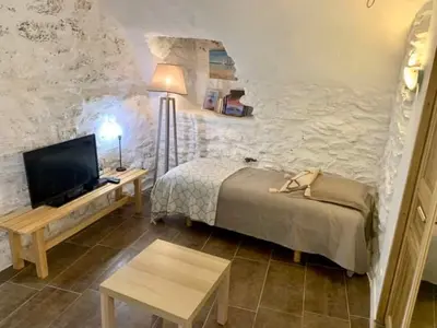 a bedroom with a bed and a tv and a table at La Corse authentique et rurale in Castifao