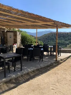 a group of tables and chairs under a pergola at La Corse authentique et rurale in Castifao