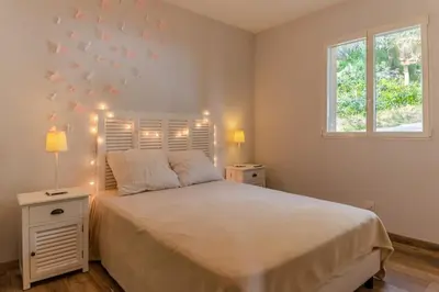 a bedroom with a large bed with lights on it at Maison vue Mer et Maquis in Olmeto