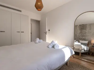 a bedroom with a large white bed and a mirror at Apartment Odeva by Interhome in Bonifacio