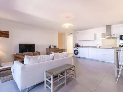 a living room with a couch and a kitchen at Apartment Odeva by Interhome in Bonifacio
