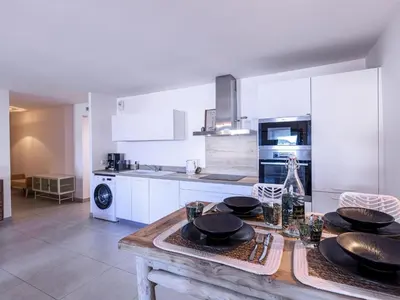 a kitchen with a wooden table with black dishes on it at Apartment Odeva by Interhome in Bonifacio