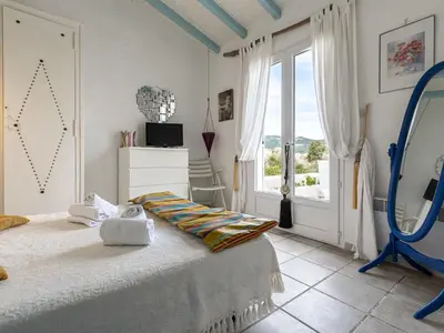 a bedroom with a bed and a large window at Holiday Home Paulka by Interhome in Sainte-Lucie de Porto-Vecchio