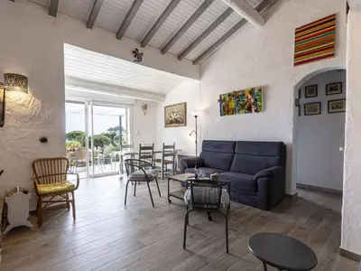 a living room with a couch and tables and chairs at Holiday Home Samba by Interhome in Sainte-Lucie de Porto-Vecchio