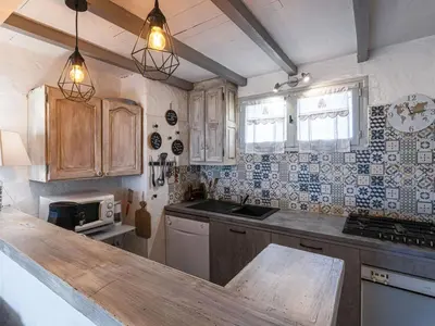 a kitchen with wooden cabinets and a counter top at Holiday Home Samba by Interhome in Sainte-Lucie de Porto-Vecchio