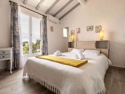a bedroom with a large bed with a large window at Holiday Home Samba by Interhome in Sainte-Lucie de Porto-Vecchio