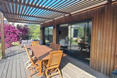 a wooden table and chairs on a wooden deck at Maison de vacances avec piscine proche mer et montagne in Ghisonaccia