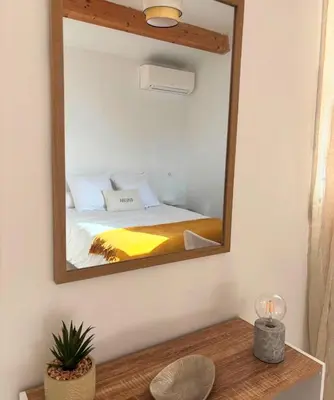 a mirror on a wall with a bed in a room at Appartement 2 personnes bord de mer in Sagone
