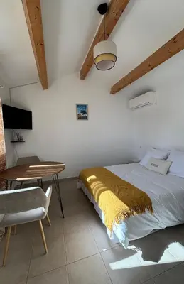 a bedroom with a bed and a table and a desk at Appartement 2 personnes bord de mer in Sagone