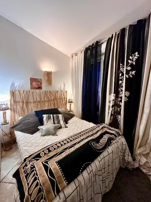 a bedroom with a bed with a black and white blanket at les pivoines in Borgo