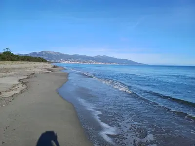 a shadow of a person walking on the beach at les pivoines in Borgo