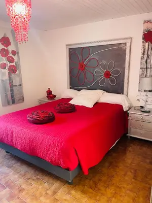 a bedroom with a large red bed with red blankets at À casetta in Albertacce