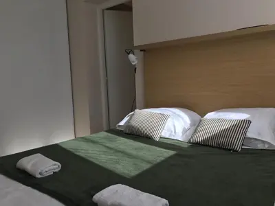 a bed with two pillows on top of it at T3 Corse vue mer. pieds dans l'eau N164 in Linguizzetta