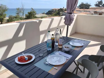 a blue table with food and drinks on a balcony at T3 Corse vue mer. pieds dans l'eau N164 in Linguizzetta