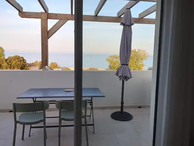 a table and chairs and an umbrella on a balcony at T3 Corse vue mer. pieds dans l'eau N164 in Linguizzetta