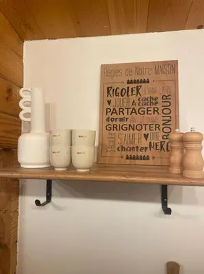 a shelf with cups and a sign on a wall at Chalet in Tasso