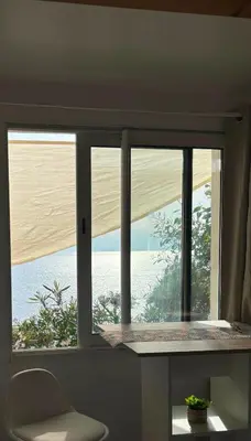 a window in a room with a view of the ocean at Appartement bord de mer 2 personnes in Sagone