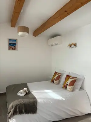 a dog laying on a bed in a bedroom at Appartement bord de mer 2 personnes in Sagone