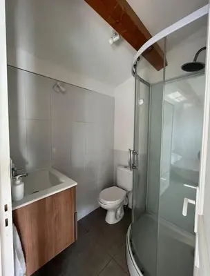 a bathroom with a toilet and a glass shower at Appartement bord de mer 2 personnes in Sagone