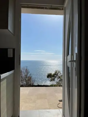 a door to a room with a view of the ocean at Appartement bord de mer 2 personnes in Sagone