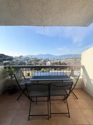 a balcony with a table and a view of the city at Appartement T2 vue mer in Porticcio