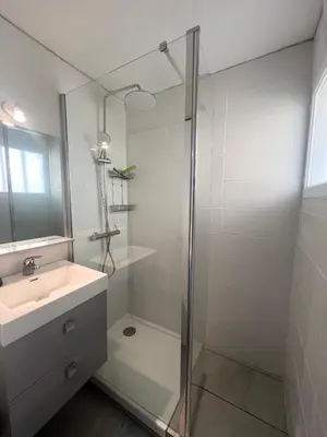 a bathroom with a glass shower and a sink at Appartement T2 vue mer in Porticcio