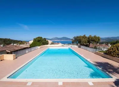 a swimming pool with a view of the water at Appartement T2 vue mer in Porticcio
