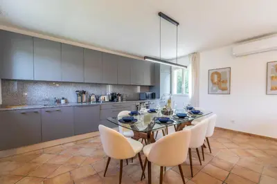 a dining room with a table and chairs in a kitchen at Résidence Casaviva in Calvi