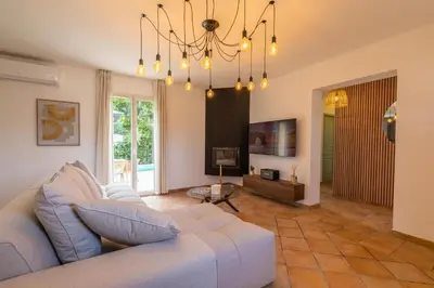 a living room with a couch and a chandelier at Résidence Casaviva in Calvi