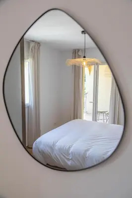 a mirror reflecting a bed in a bedroom at Résidence Casaviva in Calvi