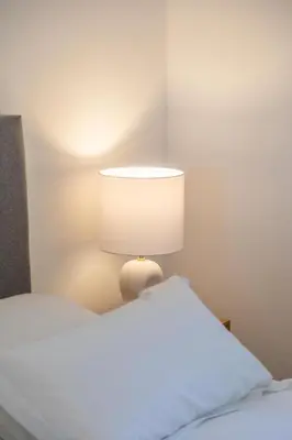 a bed with a lamp next to a white bed at Résidence Casaviva in Calvi
