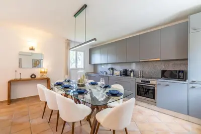 a kitchen with a dining room table and chairs at Résidence Casaviva in Calvi