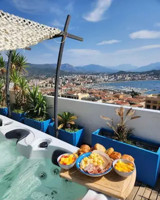 a tray of food on a table next to a swimming pool at Penthouse panoramique avec Jacuzzi in Ajaccio