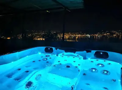 a hot tub with a view of a city at night at Penthouse panoramique avec Jacuzzi in Ajaccio