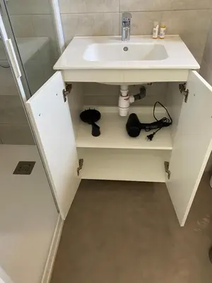 a bathroom with a white sink and a shelf at Appartement 2 pièces dans une résidence hôtelière Les Hameaux de Saint-Cyprien in Lecci