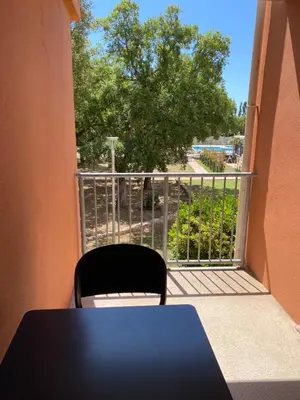 a black table and a chair on a balcony at Appartement 2 pièces dans une résidence hôtelière Les Hameaux de Saint-Cyprien in Lecci