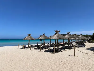 a beach with chairs and umbrellas and the ocean at Appartement 2 pièces dans une résidence hôtelière Les Hameaux de Saint-Cyprien in Lecci