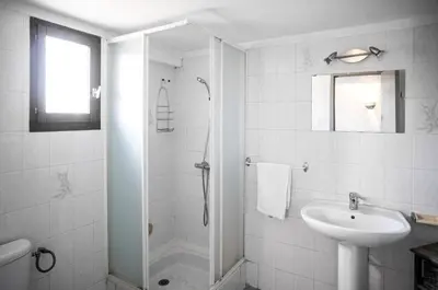 a white bathroom with a shower and a sink at Bas de villa, Haute-Corse, vue montagne, 5min des plages in Prunelli-di-Fiumorbo