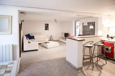a kitchen and living room with a counter and stools at Bas de villa, Haute-Corse, vue montagne, 5min des plages in Prunelli-di-Fiumorbo