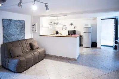 a living room with a couch and a kitchen at Bas de villa, Haute-Corse, vue montagne, 5min des plages in Prunelli-di-Fiumorbo