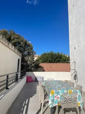 a patio with a table and chairs on a balcony at Les Toits de Moriani in San-Nicolao