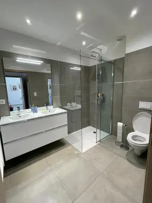 a bathroom with a shower and a sink and a toilet at Les Toits de Moriani in San-Nicolao