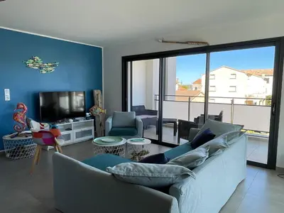 a living room with a couch and a tv at Les Toits de Moriani in San-Nicolao