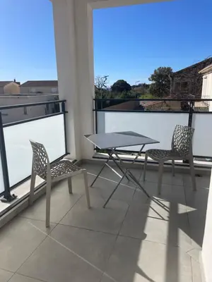 a patio with two chairs and a table on a balcony at Les Toits de Moriani in San-Nicolao