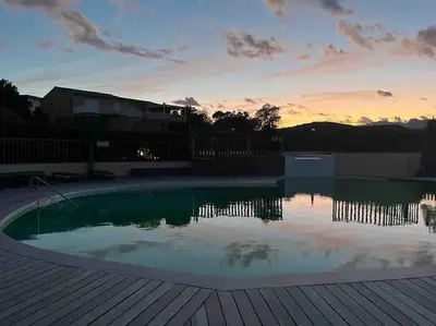 a swimming pool with a sunset in the background at Appartement 2 chambres, mezzanine et piscine in Porto-Vecchio