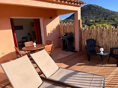 a patio with chairs and a table and a grill at Appartement 2 chambres, mezzanine et piscine in Porto-Vecchio