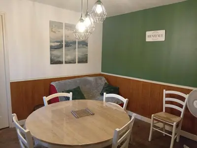 a dining room with a table and a couch at Ravissant appartement au cœur de Piana in Piana