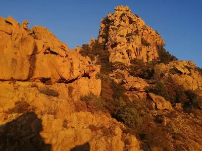 a rocky mountain with trees on top of it at Ravissant appartement au cœur de Piana in Piana